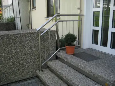 Hauszugang mit drei Stufen, seitlich befindet sich ein Geländer aus Edelstahl
