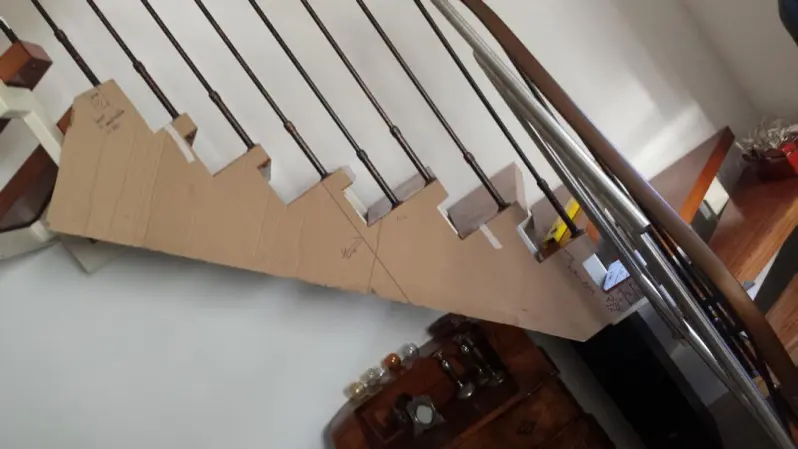 Frontansicht des Mittelbereiches einer Holztreppe, an der Treppe ist eine Schablone der Treppe aufgeklebt
